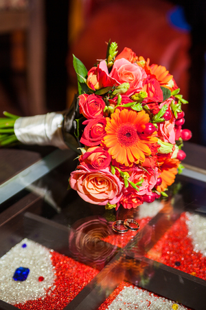 rings and beautiful tender bridal bouquet from different roses and other flowers close upの写真素材