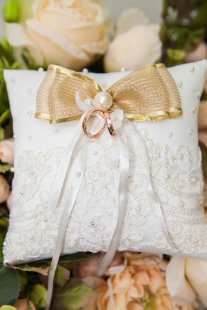 wedding rings on white lace pillowの写真素材