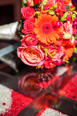 rings and beautiful tender bridal bouquet from different roses and other flowers close upの写真素材
