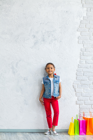 cute African girl with shopping bags Against the gray wallの写真素材