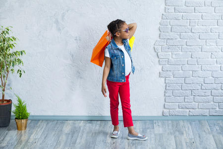 cute African girl with shopping bags Against the gray wallの写真素材
