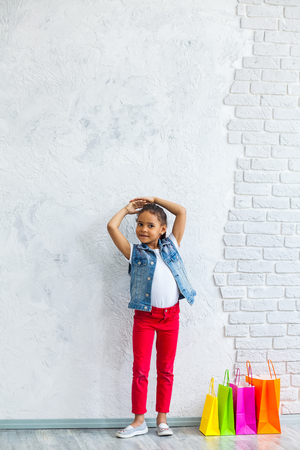 cute African girl with shopping bags Against the gray wallの写真素材