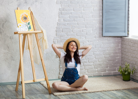 Getting creative. Woman artist painting a sunflower at homeの写真素材