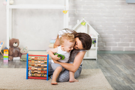Mother with child playing educational toys in the roomの写真素材