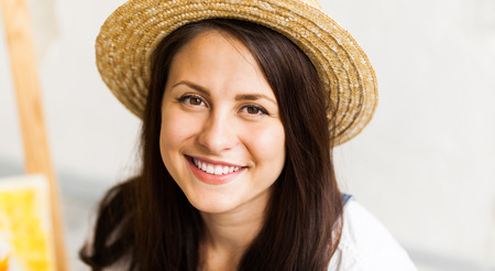 Closeup of happy smiling female artist in a straw hat の写真素材