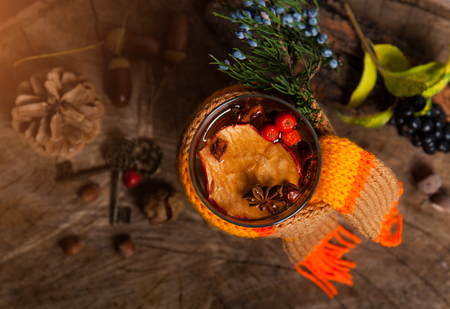Mulled wine hot steaming drink with citrus, applem berries and spices on wooden rustic background selective focus, flat lay top viewの写真素材