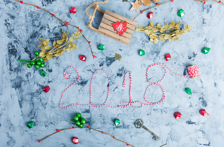 New Year 2018 background with figures, Christmas toys, New Year 2018 composition. Text 2018 made of thread. Flat lay, top view of New Year 2018 festive still lifeの写真素材