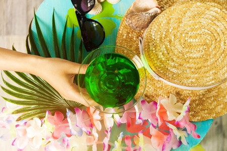 Green tropical cocktail and handの写真素材