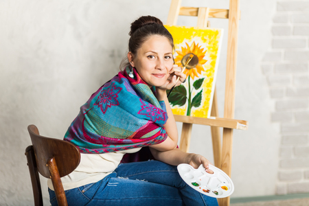 Getting creative. Woman artist painting a sunflower in art studioの写真素材