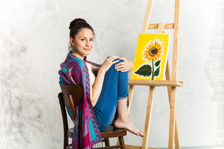 Getting creative. Woman artist and her art work a sunflowerの写真素材