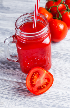 Tomato juice in Mason Jar and Fresh Grape of Whole and half Tomato on rustic tableの写真素材