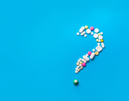 Pills In The Shape Of A Question Mark Over White Backgroundの写真素材