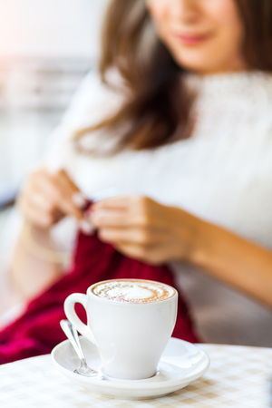 I can create anywhere. Woman knitting on terrace with a cup of coffee.の写真素材