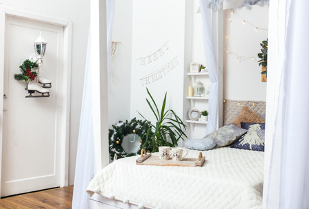 White cozy bed and Christmas lightsの写真素材