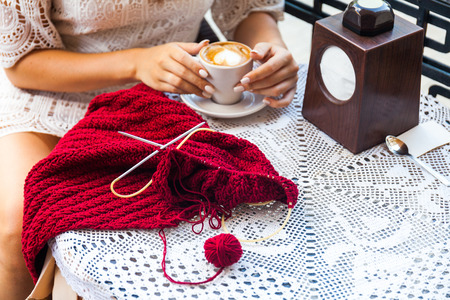 I can create anywhere. Woman knitting on terrace with a cup of coffee.の写真素材