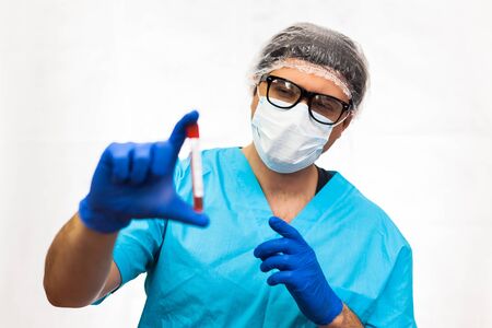 laboratory technician in mask hold on blood sample tube for corona virus test , COVID 19 testの写真素材