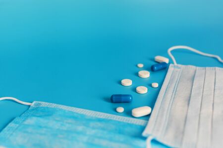 Novel coronavirus disease named 2019 nCoV with breathing mask and pills, selective focus on blue background with Copy spaceの写真素材