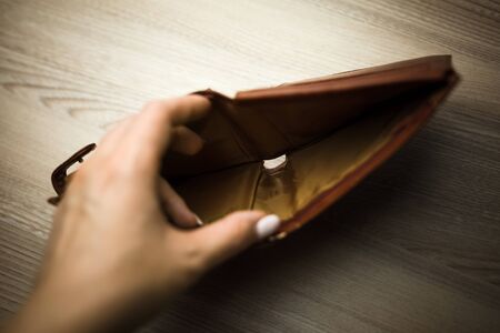 Hand holding empty old wallet on white background. Poverty and financial crisis concept. Soft focusの写真素材