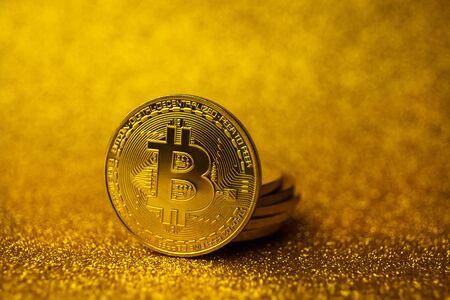 Golden Bitcoins stacked on the cool golden sparkling background with Copy space. Bitcoin cryptocurrency. Crypto currency concept. Horizontal background, Soft focusの写真素材