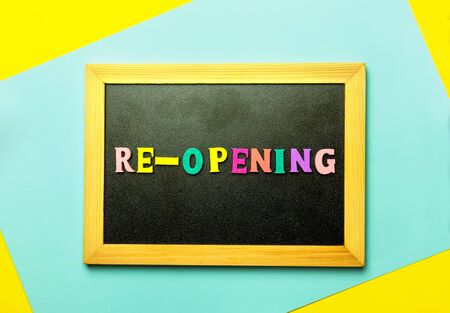 Blackboard written Re-opening, message on a blackboard on multi-colored backgroundの写真素材