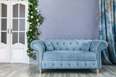 Blue sofa chester on a background of gray wall in classic livingroomの写真素材