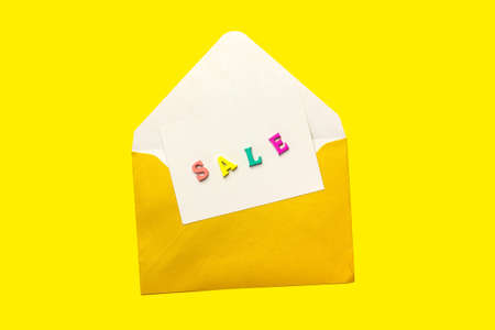 sale note made of wooden letters in an open envelope isolated on Yellow background