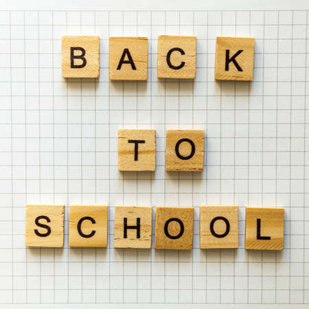 the inscription BACK to SCHOOL in wooden letters with shadows on office notebook sheetの写真素材