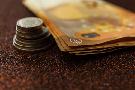 Tower with euro coins and euro banknotes on sparkle background.