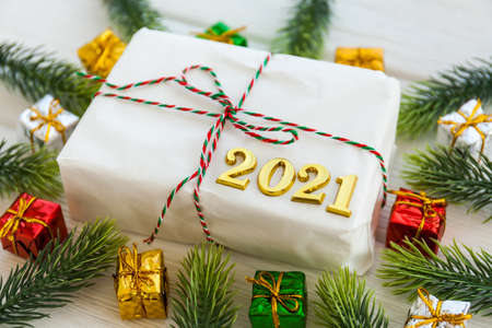 Christmas present and Happy New Year 2021 on wooden background. Handmade gift Christmas box, fir...