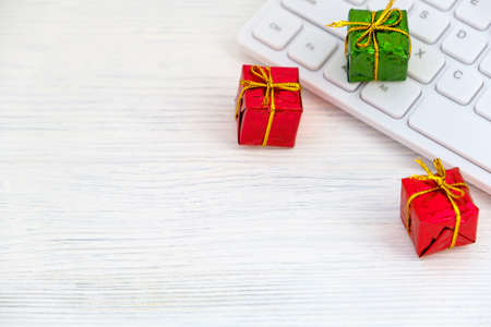 Red and green presents on computer keyboard - christmas online shopping concept