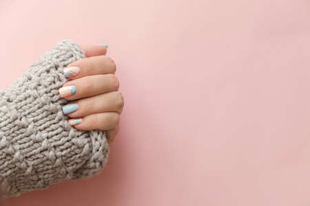 Female hand manicure close up view with knitted sweater on pink background. Trendy Geometric Nail Art Manicure. Manicure salon banner conceptの写真素材