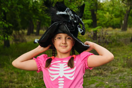 Happy Halloween. Portrait of a cute little child girl in a witch costume. Photo with art noise, soft...