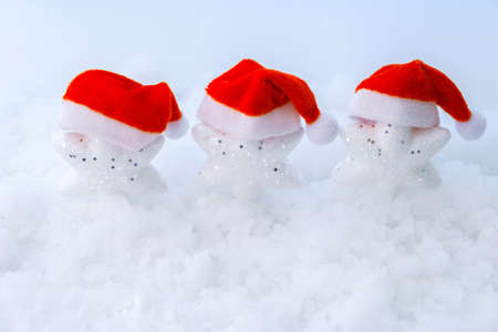 Christmas background with white stars wearing red Santa hats. Blank for a holiday card or invitationの写真素材