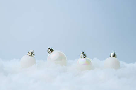 Decoration of white pearly christmas baubles in line on snow abstract light blue background, copy spaceの写真素材