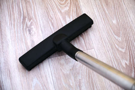Head of modern vacuum cleaner cleaning the floor. Top view.