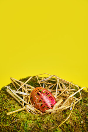easter basket nest with easter eggs on yellow background with copy space