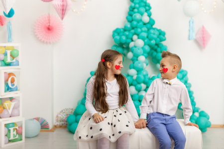 Cute couple of kids with balloons. Valentine's Day and love concept, studio shotの写真素材