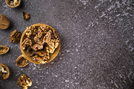 Walnut in wooden bowl on black background with copy space. Top view. Wooden plate with peeled walnut on black background. Space for textの写真素材