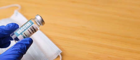 Doctor, nurse, scientist, researcher hand in blue gloves holding coronavirus, covid-19 vaccine disease preparing for vaccination, medicine and drug concept.の写真素材