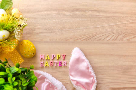 Colorful easter basket with eggs on a white wooden background, decorated with blossom spring. Springtime holidays congratulatory concept.の写真素材