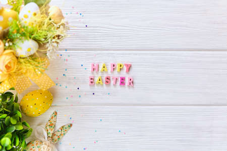 Colorful easter basket with eggs on a white wooden background, decorated with blossom spring. Springtime holidays congratulatory concept.の写真素材