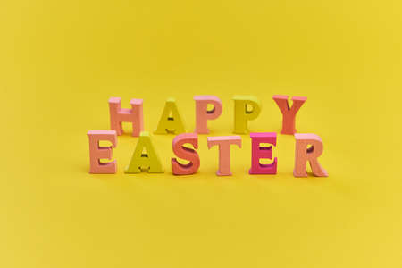 Happy Easter background, creative greetings. Inscription from multicolored wooden letters. Bright...