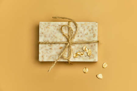 Handmade natural bath oat spa soap on beige background. Soap and oat flakes in a wooden bowl. Soap...