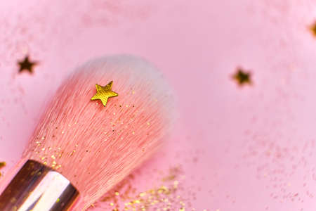Close up Makeup brush and shiny sparkles on pink background. Festive magic make up concept. Top view Flat Lay, Macro, Selective focusの写真素材