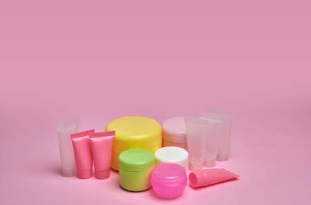 Mock-up multicolored set empty container cream pump tubes and a cream jars for skincare on pink backgroundの写真素材