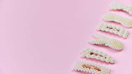 Pearl hair clips. fashionable hair accessories. Set of Hairpins different shapes with white pearls on Pink background with copy spaceの写真素材