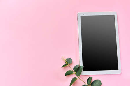 Office desk working space - Flat lay top view photo of working space with blank mock up tablet on pink background. Pastel pink yellow color copy space working desk concept.の写真素材