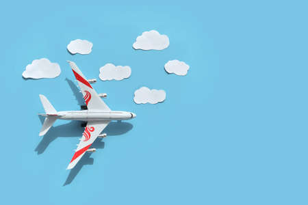 Model of Airplane, aerial view with shadow, paper art with could beautiful background. Trip by airplane. Flat lay design of travel concept with plane with blue sky. Suitable weather for flightの写真素材
