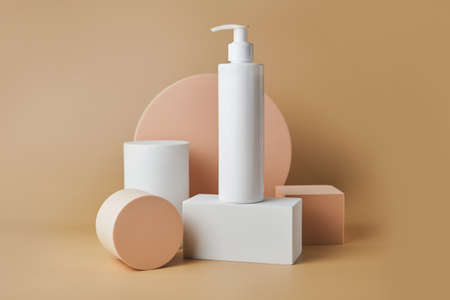 Trendy cosmetics tube on pedestal at the beige background. Unbranded blank cosmetics packages. Skincare female products advertising mockupの写真素材