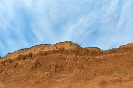 Geology. Desert landscape. Panorama view of the sandstone formation, the rocky cliffs, sand. Background or texture of sandy cliff on the coast, orange limestoneの写真素材